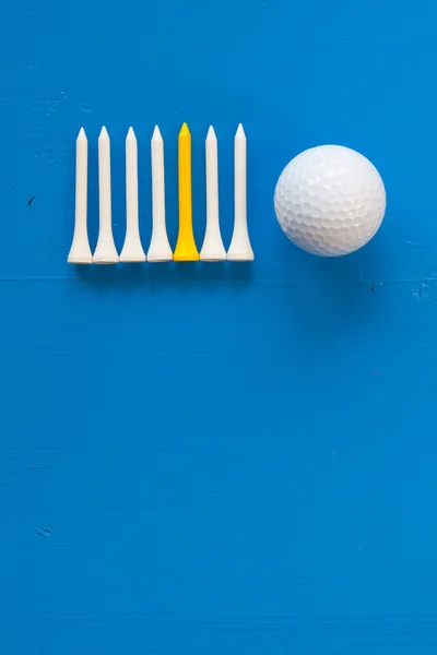 Bola de golfe e camisetas de golfe de madeira na mesa azul — Fotografia de Stock