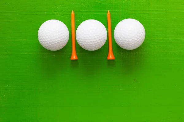 Golfballen en houten golf tees op de groene tafel — Stockfoto