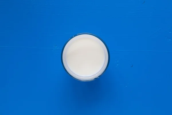 杯蓝色的木桌上的牛奶 — 图库照片