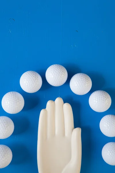 青い木製テーブルの上のゴルフ ・ ボールを持つセラミック手の詳細 — ストック写真
