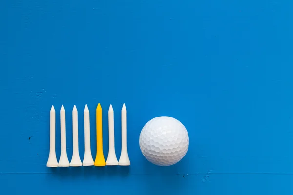 Bola de golfe e camisetas de golfe de madeira na mesa azul — Fotografia de Stock