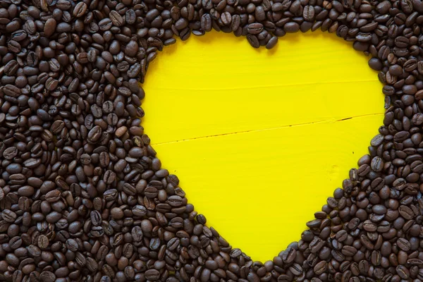 Gelbes Herz aus Kaffeebohnen — Stockfoto