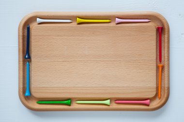 Empty cutting board with different golf tees clipart