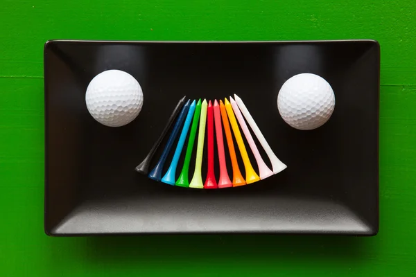 Svart keramisk rätter med golfbollar och trä tees — Stockfoto