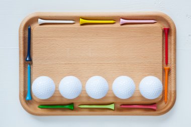 Ahşap golf tee ve golf topları ile kesme tahtası