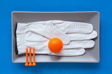 Golf eldiven üzerinde mavi arka plan ile gri seramik tabak