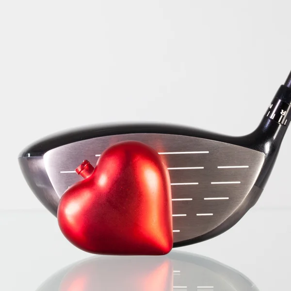 Club de golf et coeur rouge sur une table en verre — Photo