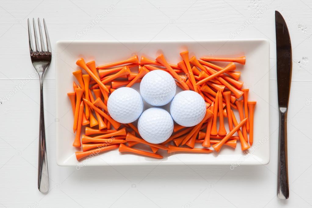 White ceramic dishes with golf balls and wooden tees 