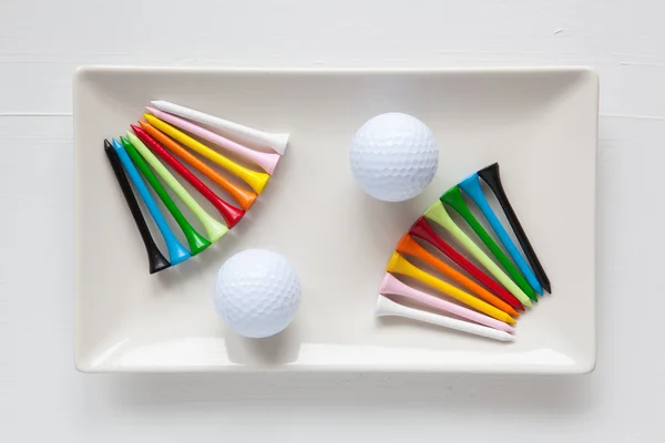 Pratos de cerâmica branca com bolas de golfe e tees de madeira — Fotografia de Stock