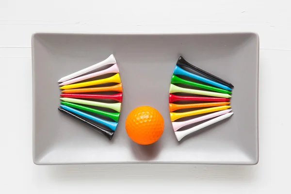 ゴルフボールと木製ティーと灰色のセラミック皿 — ストック写真