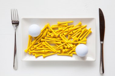 Golf topları ve ahşap tees ile beyaz seramik yemekleri 