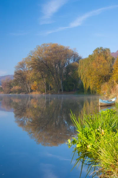 Blue canoe on the river in the mist — Stock Photo, Image