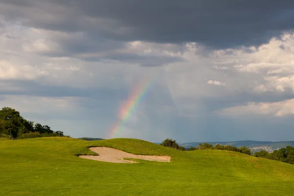 Regenboog op de lege driving range — Stockfoto