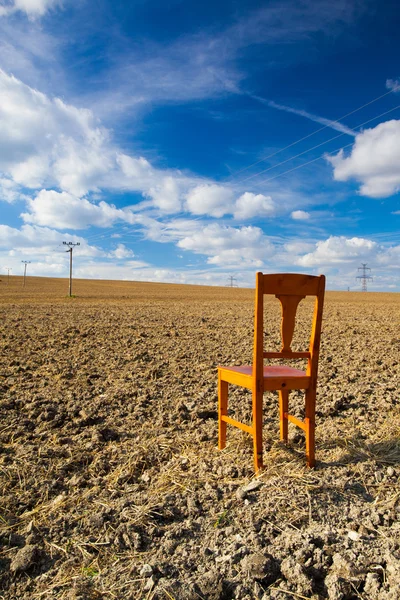 Old wooden chair on the empty field — Stock Photo, Image