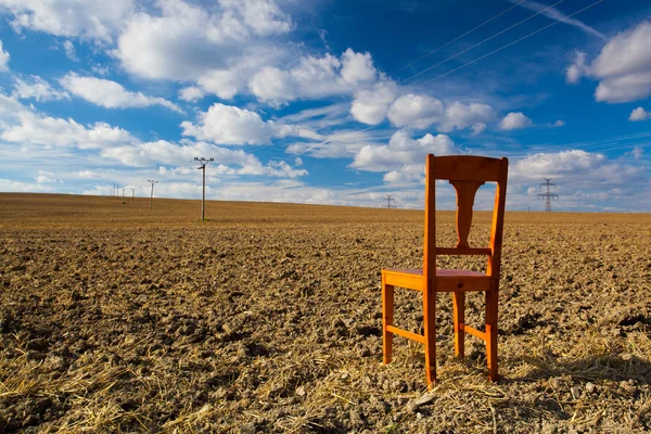 Old wooden chair on the empty field — Stock Photo, Image