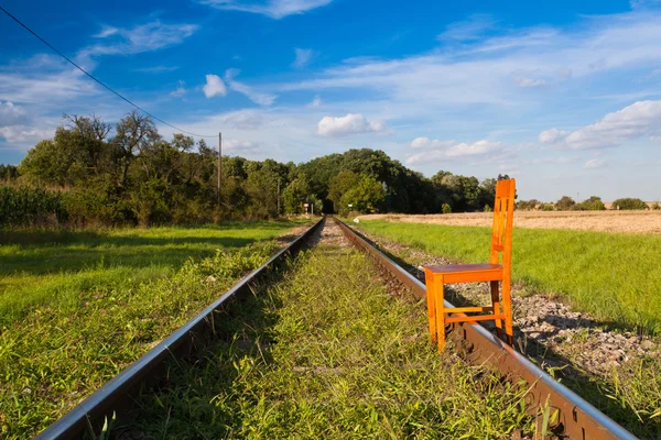 Železniční tratě a staré dřevěné židle — Stock fotografie