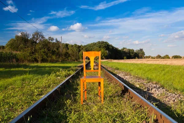 Železniční tratě a staré dřevěné židle — Stock fotografie