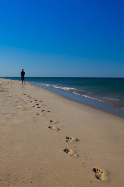 Uomo che cammina sulla spiaggia — Foto Stock