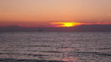 Yalnız teknede boş plaj deniz ve dramatik günbatımı