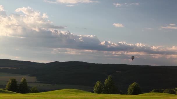 Globo de aire caliente volando sobre un campo de golf — Vídeos de Stock