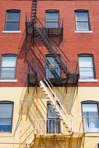 The typical american fire escape ladder zigzagging across the fa — Stock Photo, Image