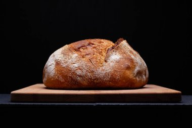 Esnaf ekmeği. Siyah zemin üzerinde taze pişmiş ekşi ekşi ekmek..