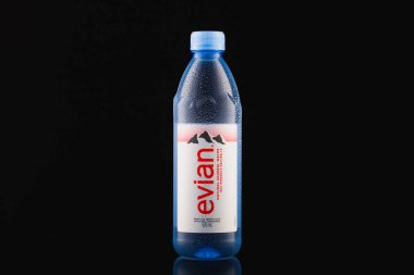 Prag, Çek Cumhuriyeti-17 Ocak 2021: Siyah zemin üzerinde Evian Natural Mineral Water. Evian, Cenevre Gölü 'nün güney kıyısındaki Evian les Bains yakınlarından gelen bir maden suyu markasıdır..