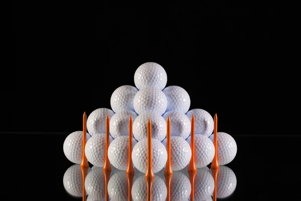 Piramide van golfballen op een zwarte achtergrond — Stockfoto