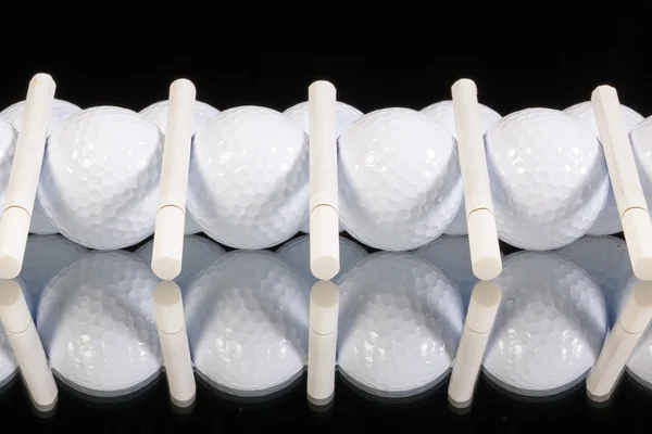 Украшение из мячей для гольфа и белых сигарет — стоковое фото