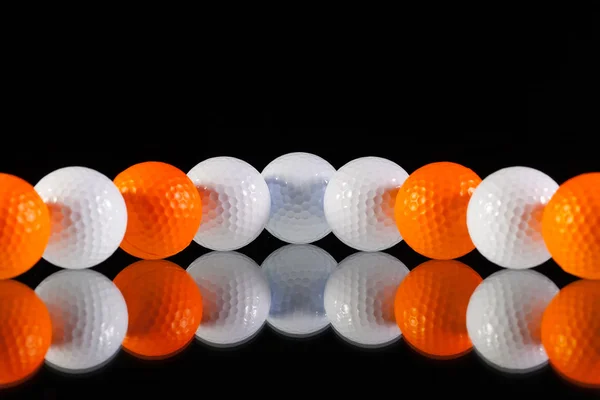 Мячи для гольфа на столе из черного стекла — стоковое фото