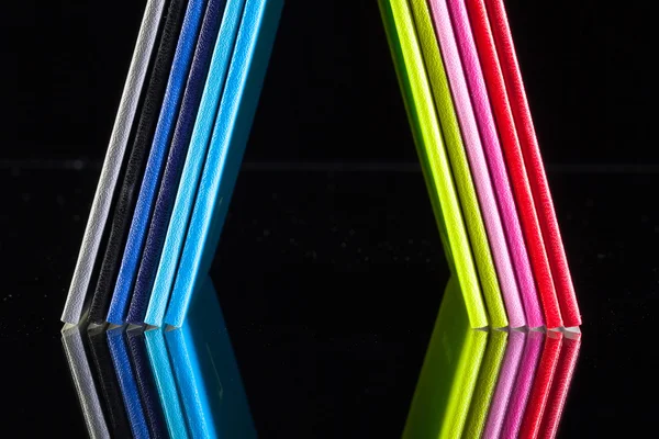Dvanáct různých barev diáře na stole sklenice — Stock fotografie