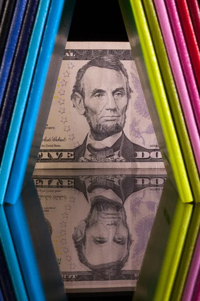 Twelve different colors diaries and US dollar banknote on a glas — Stock Photo, Image