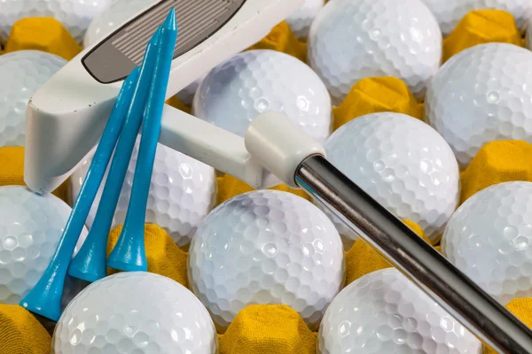 White golf balls in the yellow box and golf putter — Stock Photo, Image