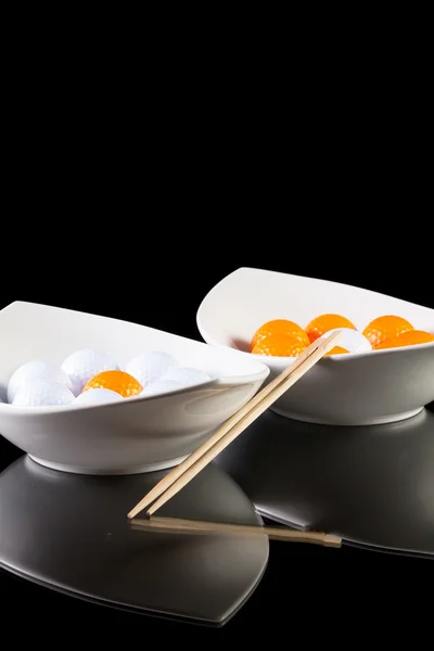 Deux bols en céramique blanche avec des balles de golf sur la table en verre — Photo