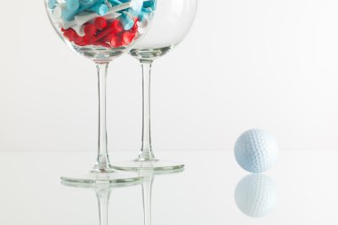 İki kadeh şarap ve golf ekipmanları