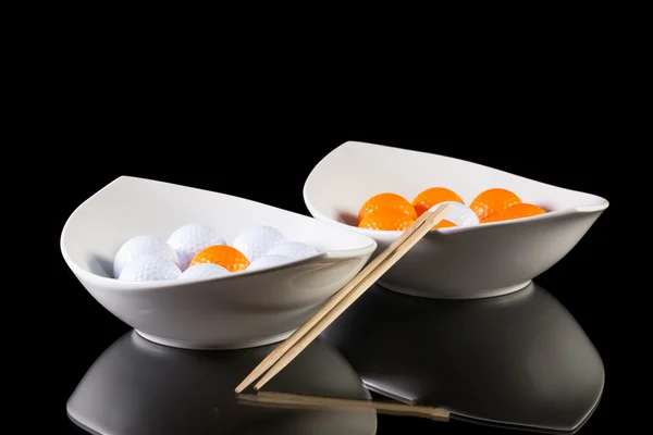 Deux bols en céramique blanche avec des balles de golf sur la table en verre — Photo