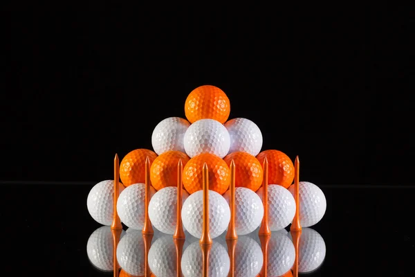 Pyramid of golf balls on a black background — Stock Photo, Image