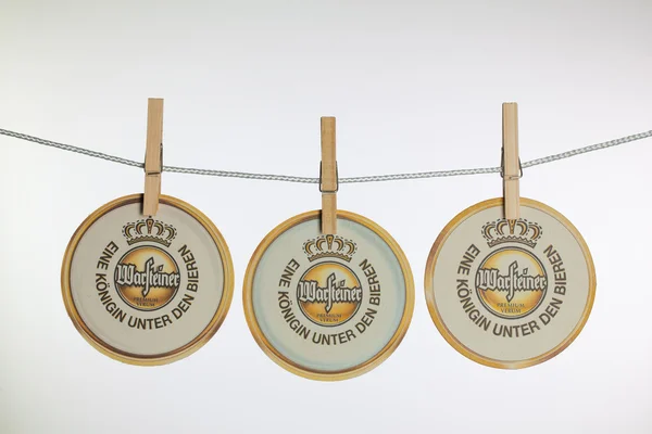 Beermats from Warsteiner beer  hanging from a clothesline. — Stock Photo, Image