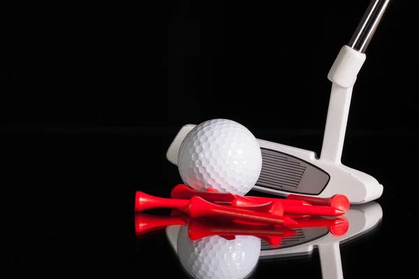 Golf putter et équipements dorés sur le bureau en verre noir — Photo