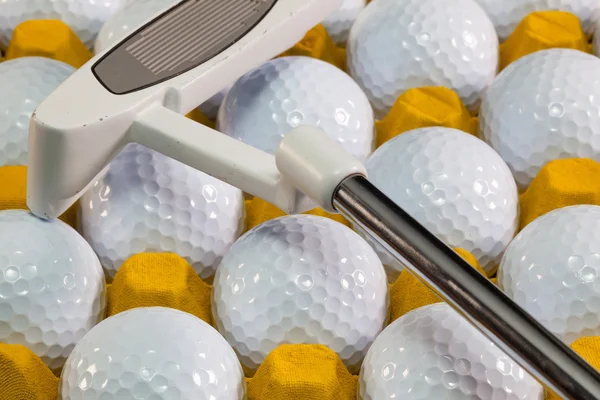 Bolas de golf blancas en la caja amarilla y putter de golf — Foto de Stock