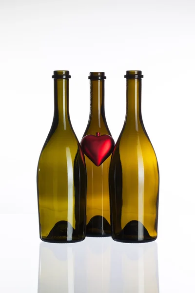 Порожні пляшки вина і символ любові — стокове фото