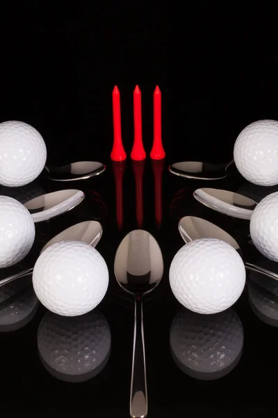 杯と黒のガラス テーブルの上のゴルフ用品 — ストック写真