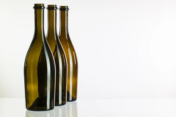 Пустые бутылки вина на стеклянном столе — стоковое фото