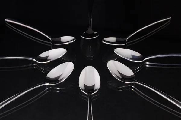 Colheres de chá na mesa de vidro preto — Fotografia de Stock