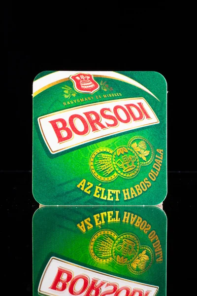 Beermat from Borsodi beer on a glass table. — Stock Photo, Image