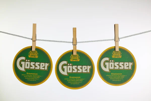 Beermats from Gosser beer hanging from a clothesline. — Stock Photo, Image