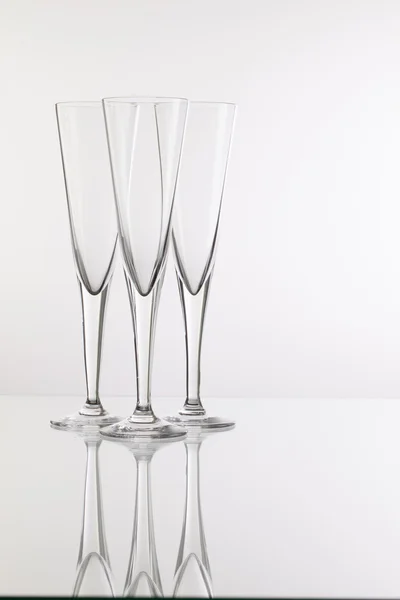Пустые бокалы для шампанского на стеклянном столе — стоковое фото