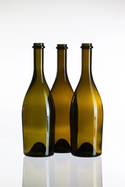 Tomma flaskor vin på ett skrivbord med glasskiva — Stockfoto