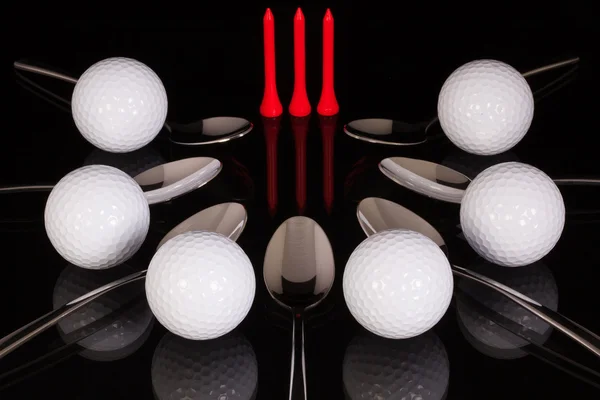 Cuillères à café et équipements de golf sur la table en verre noir — Photo