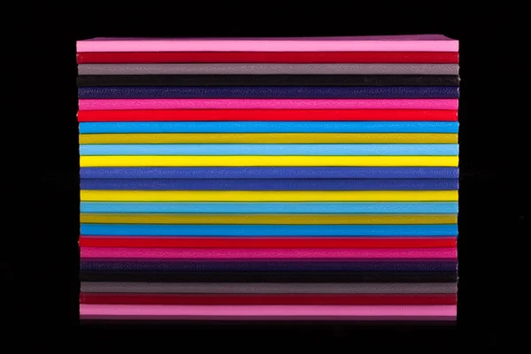 Doce diarios de colores diferentes en una mesa de vidrio negro —  Fotos de Stock